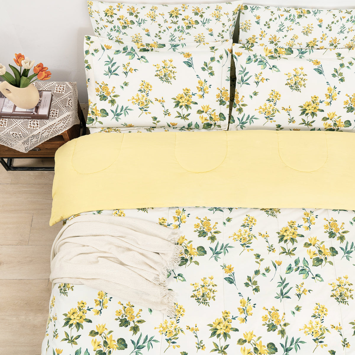 Floral pillows and comforter folded back to show a pale yellow layer