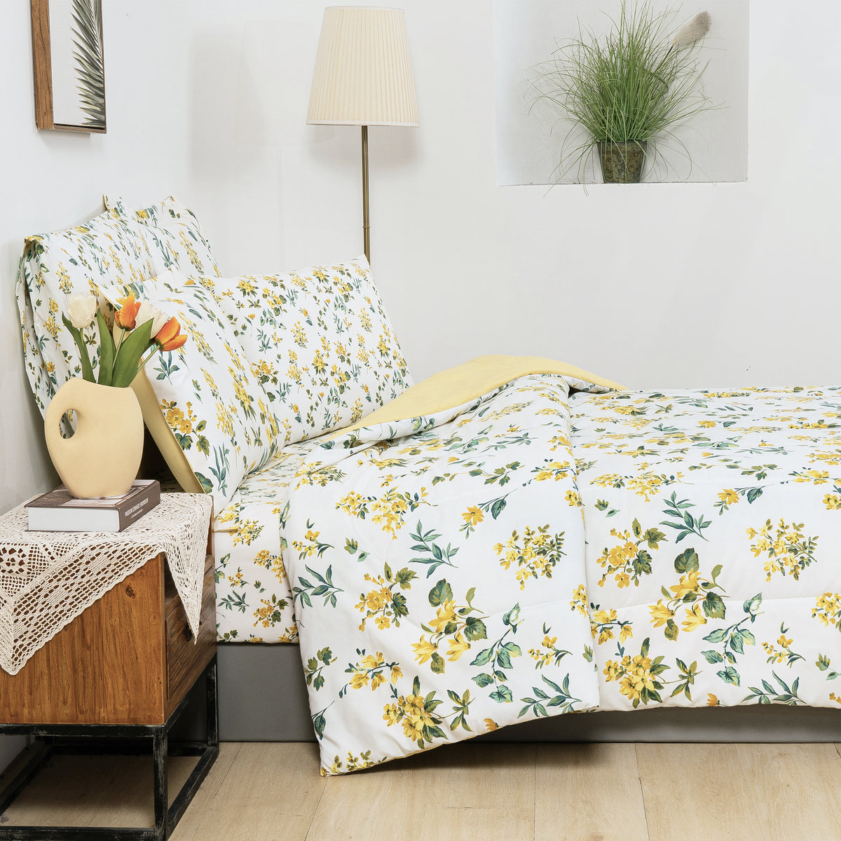 Yellow daisy comforter and floral pillows in a styled bedroom
